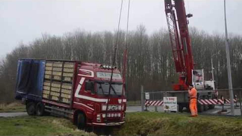 Vrachtwagen  hangt boven sloot bij Siddeburen