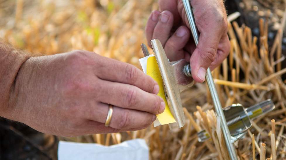 Herman Krebbers hangt vloeistofgevoelige papiertjes op om effect spuittechniek inzichtelijk te maken.