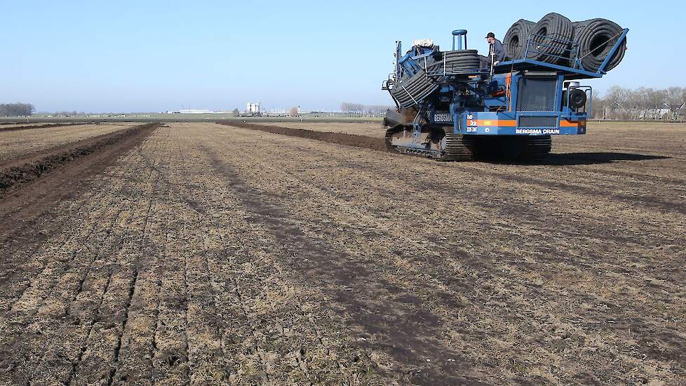 Tijdens de eerste werkgang trekt de machine een sleuf inclusief drainageslang.