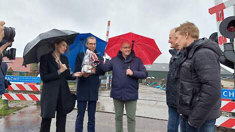 Vlnr: regiodirecteur Veenhof van ProRail, gedeputeerde De Vries, wethouder Rietman en melkveehouder Bokma met zijn zoon bij de pas beveiligde spoorwegovergang.
