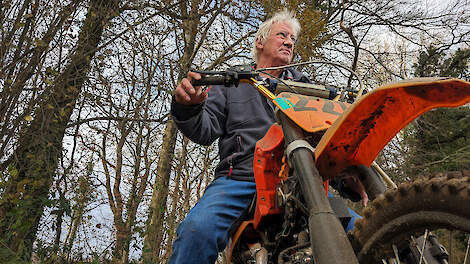 Op het weggetje langs zijn huis, waarover de crossers altijd naar het terrein liepen, poseert Dick Regelink met een door een maat zelf in elkaar gezette oude motor.